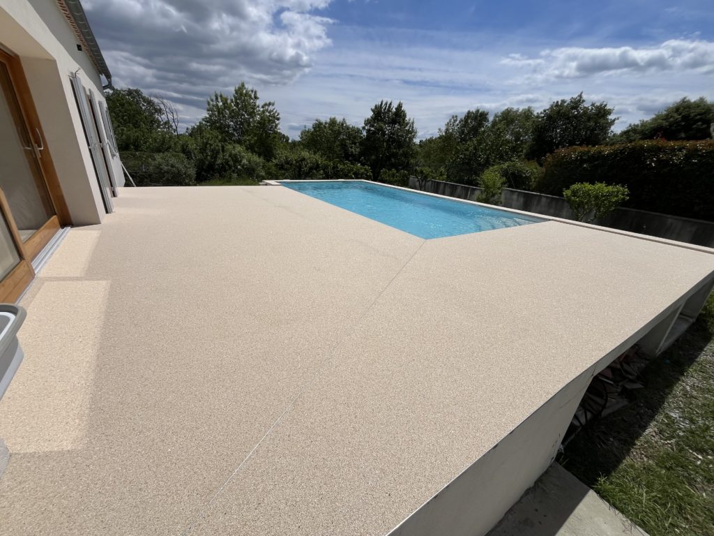 Plage de piscine en granulat de marbre drainant, sol sans joints réalisé par Stucopierre à Nîmes