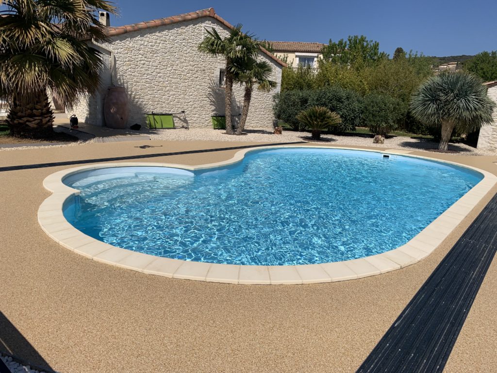 Plage de piscine en granulat de marbre drainant, sol sans joints réalisé par Stucopierre secteur Alès